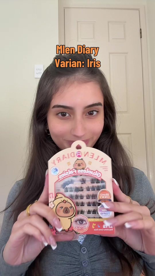 Video cover: Aisha holding a boxed set of cluster lashes up to the camera.